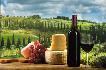Red wine in vintage light with cheese and fruits.