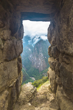 Peru, Machu Picchu. Mountains trough the wall window.