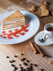 White plate with a cake on a wooden table, surrounded by decor