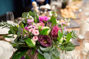 a bouquet of flowers at the banquet table in a restaurant