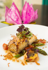 Delicious oven baked Basa. A fillet of tender fish marinated with chilli, lemongrass, kumquat sauce, Asian green herbs and home made kimchi. Vietnamese food.