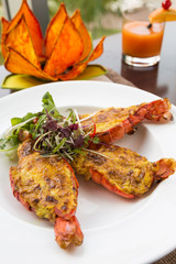 Beautiful and delicious giant oven roasted tiger prawns with lemongrass and five-spiced sabayon. Vietnamese seafood dish, served on a white plate.