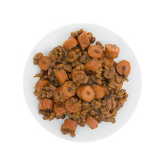 Top view of beans and hot dogs on a plate isolated on a white background.