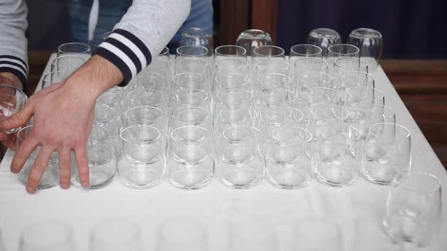 Wedding catering preparation, making a pyramid from glasses, 4K