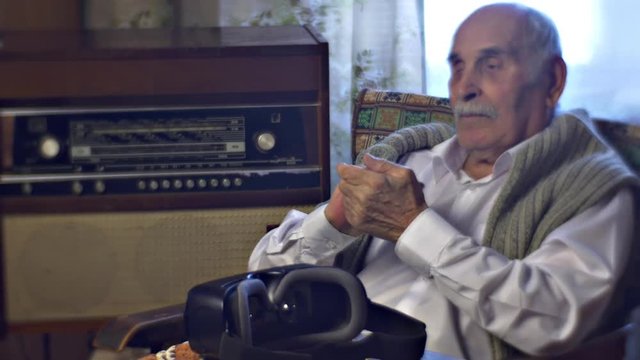 Grey-Headed Man at the Window Sitting in Armchair Taps His Fingers Happy to See His Guests vr Headset is Placed to the Table Old Radiogram Link of Times