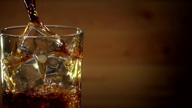 Cola Pouring Into Glass With Ice Cubes. Close Up Soda Soft Drink. Slow motion 240 fps.