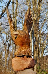 Holzgeschnitzter Adler auf einem Stein im Wald