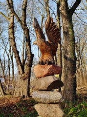 Holzgeschnitzter Adler auf Steinhaufen