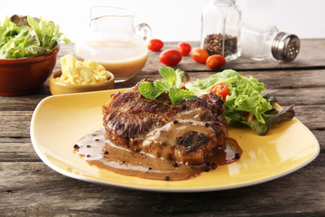The steak set with the black pepper sauce and the potato and some vegetable as foods background or print card