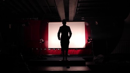 Man on stage takes a bow and thanks audience