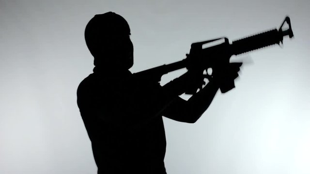 Silhouette of man with assault rifle