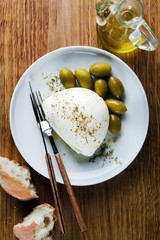Mozzarella Cheese and Green Olives with bread on cutting board o