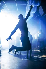 Foto op Plexiglas silhouet man sprong het plezier en de vreugde in club night party © alexkoral