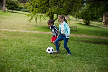 Obraz premium Boy and girl playing football