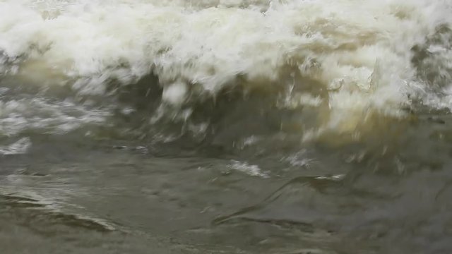 Torrente de agua  descendiendo en un rio , formando espuma al romper
