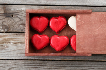 Red macaroons desserts on wooden background. dessert for breakfast on Valentine's Day