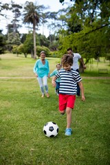 Happy family playing football in park