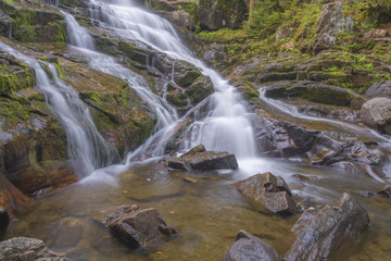 Waterfall Flows Down Warm Colored Bedrock