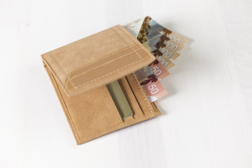 Canadian Dollars and credit cards in mustard coloured leather wallet