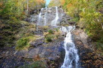 View of a waterfall from a mountain with colorful trees after a hike in the forest shot in daylight...