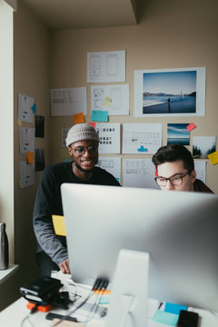 Two Men Working Togehter In A Small Home Office.