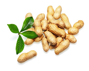 Pile of dry roasted peanuts with green leaves isolated on white background. Closeup.