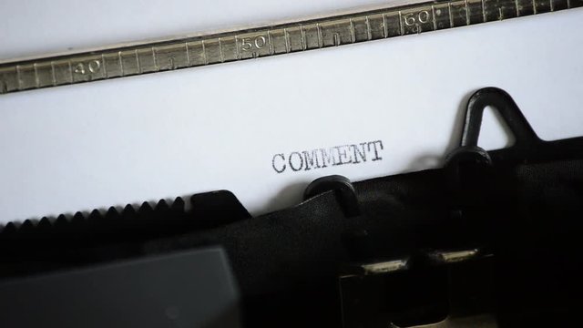 Typing the word COMMENT with an old manual typewriter