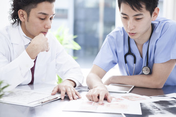 Two doctors are discussing treatment policy in the examination room