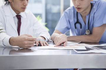 Two doctors are seriously talking in the examination room
