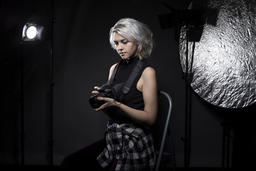Creative female professional photographer in a strobe lighting studio.  She portrays an independent...