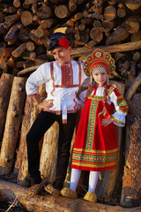 Obraz premium Two Russian kids in russian folk costume boy and girl playing together and emotionally smiling