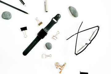 White office table desk with supplies. Glasses, watch, clips and stones on white background. Flat lay, top view.