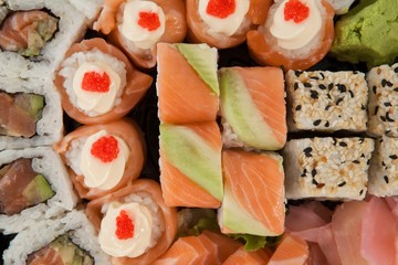Assorted sushi set served in white box against white background