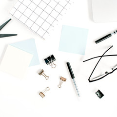 White office desk frame with paper blank and supplies. Laptop, notebook, pen, clips, glasses and office supplies on white background. Flat lay, top view, mockup.