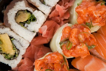 Assorted sushi set served in white box against white background
