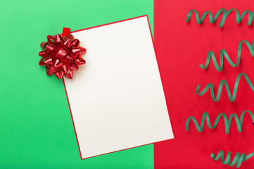 Blank card with red bow and streamer on colorful background