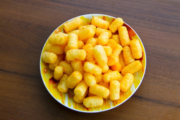 Corn sticks in bowl on wooden table