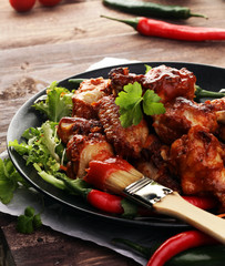 barbecue chicken wings close up on wooden tray with red spice sa
