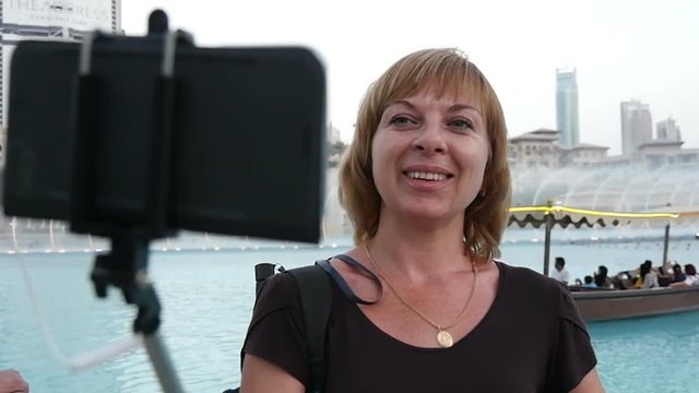 Dubai quay with one female tourist making a selfie with a selfie stick