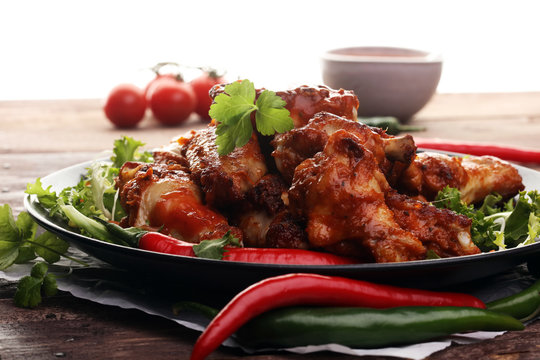 barbecue chicken wings close up on wooden tray with red spice sa