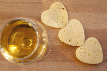 Heart shaped cheese and a glass of wine. Valentine's Day