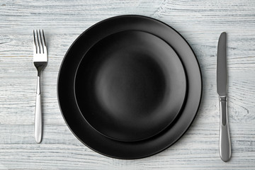Empty plate, fork  and knife on wooden background