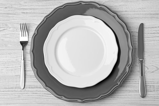 Empty plate, fork  and knife on wooden background