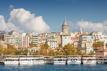 Fototapeta premium Sunny view of Bosphorus with excursion boats and Galata Tower, Istanbul, Turkey.