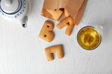 Cookie alphabet and cup of tea, top view