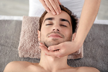 Fototapeta na wymiar Man having face massage in spa salon