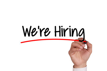 Human hand writing WE'RE HIRING on whiteboard