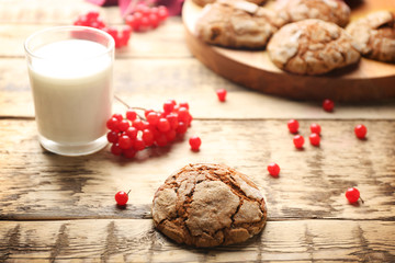 Delicious chocolate cookie and viburnum on wooden table