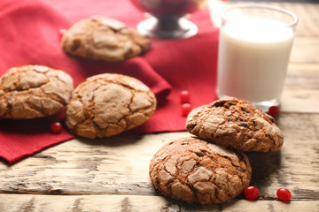 Delicious chocolate cookies, glass of milk and red napkin on rustic wooden table, closeup