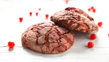 Delicious chocolate cookies and viburnum on white wooden table, closeup